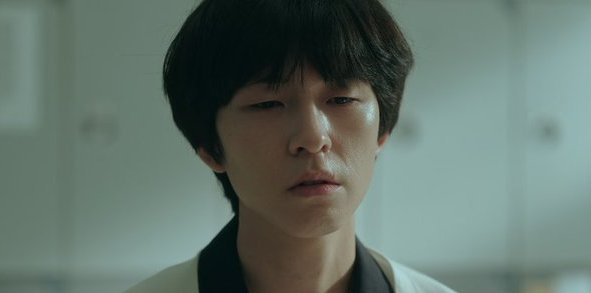 "Screenshot from Weak Hero Class 1 showing Hong Kyung as Oh Beom-seok with a blank, emotionally distant expression, reflecting his mental state after the traumatic events he caused."