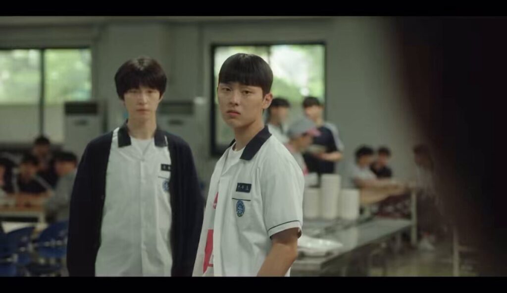 "Screenshot from Weak Hero Class 1 showing Hong Kyung as Oh Beom-seok and Choi Hyun-wook as Ahn Su-ho in a tense confrontation at a restaurant, capturing the breakdown of their friendship."