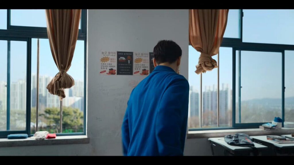 "Go-tak in his signature blue hoodie doing cleaning duties - showing his diligent, responsible side that made him such a reliable friend to everyone at Eunjang High. Source: Weak Hero Class 2, Netflix"
