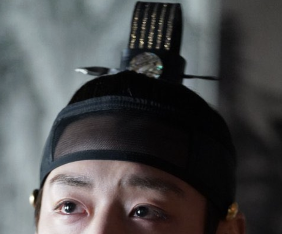 Actor Park Ji-hoon portraying King Danjong with trembling, fearful eyes gazing toward the sky, his sangtugwan crown beautifully detailed. Official promotional still from The King's Warden (2026).